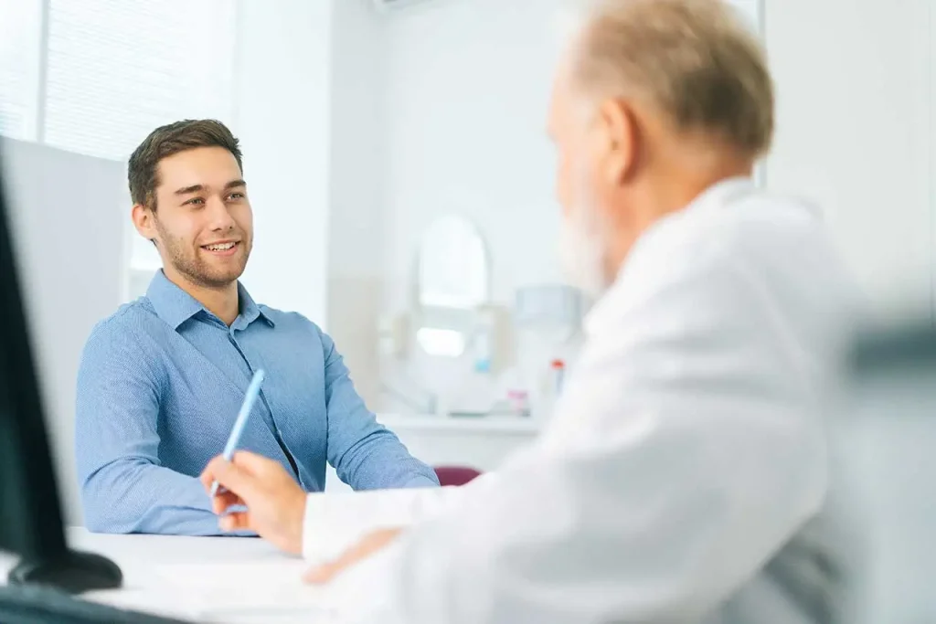 homem jovem conversando com o seu médico no consultório